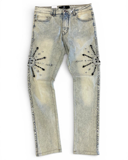 Distressed denim jeans with embellishments on a white background