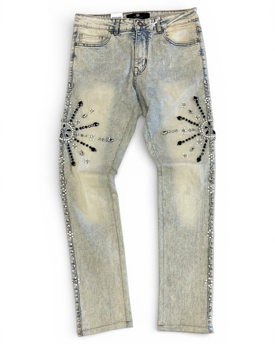 Distressed denim jeans with embellishments on a white background