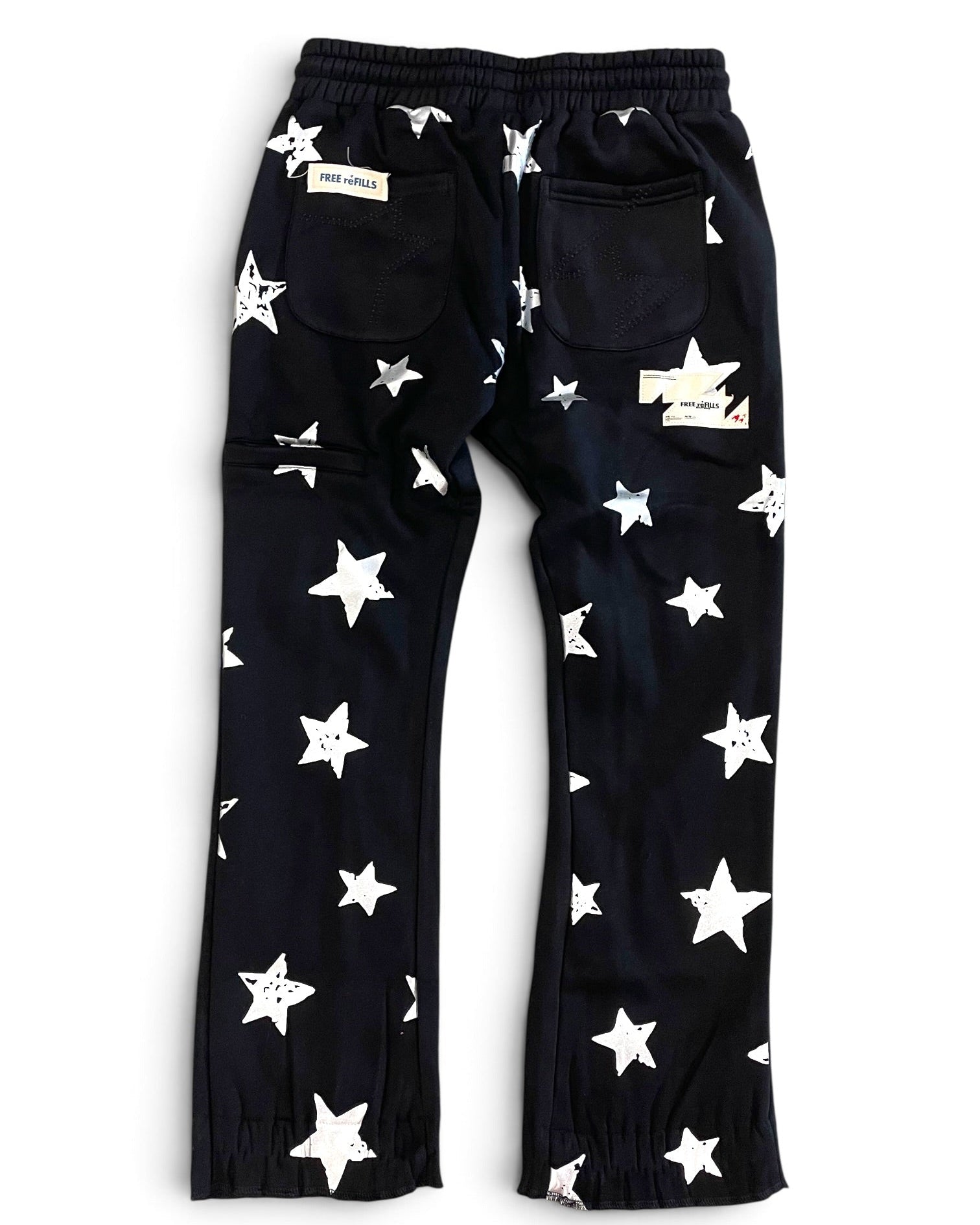 Black pants with an all-over white star pattern, featuring an elastic waistband, side cargo pockets, and elastic cuffs at the ankles, shown flat on a white background.