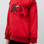 Red sweatshirt with star design worn by a person on a white background