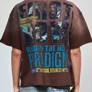 Person wearing a brown t-shirt with colorful text on the back, standing against a plain background.