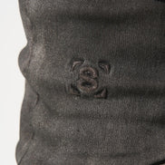 Close-up of a dark gray fabric with a small embroidered design on a white background