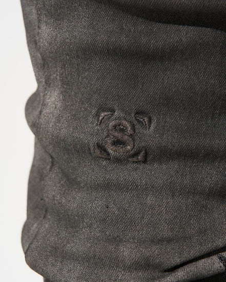 Close-up of a dark gray fabric with a small embroidered design on a white background