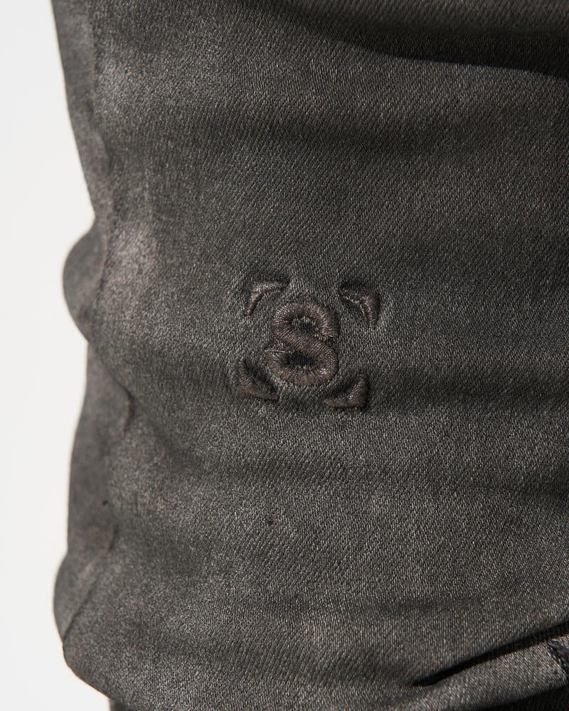 Close-up of a dark gray fabric with a small embroidered design on a white background