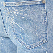 Close-up of a blue denim pocket with decorative stitching.