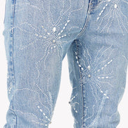 Light blue jeans with decorative patterns on a white background