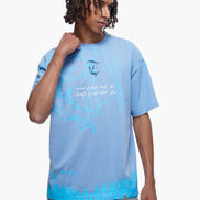Man wearing a light blue t-shirt with a graphic design on a white background