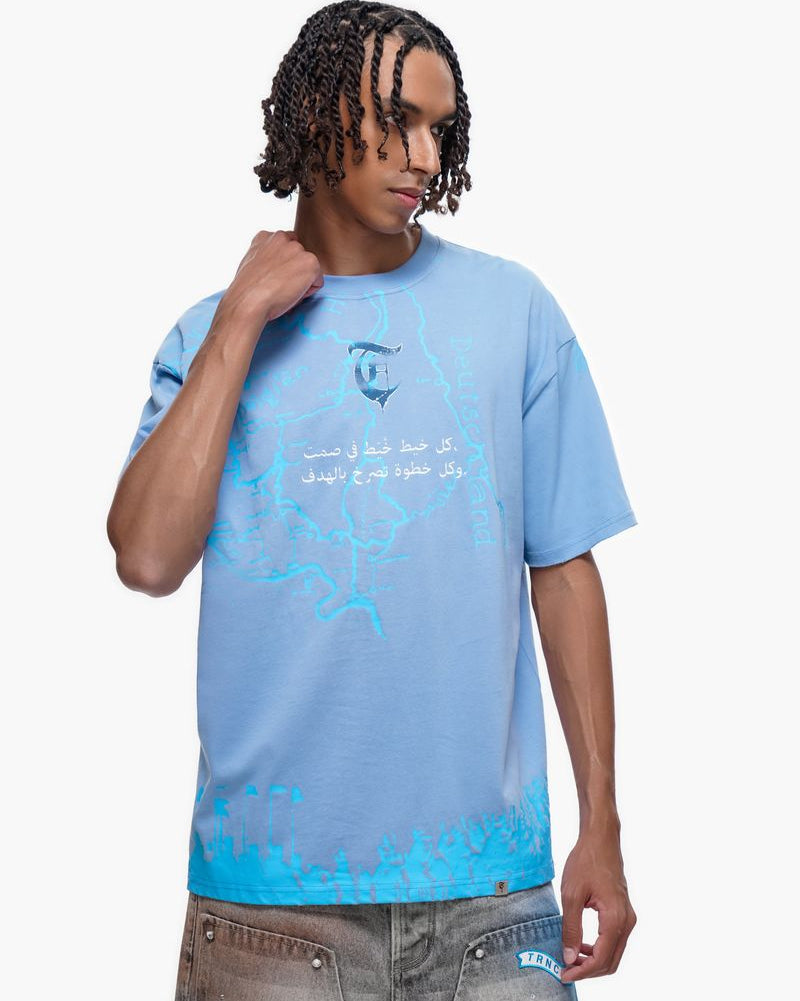 Man wearing a light blue t-shirt with a graphic design on a white background