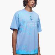 Person wearing a light blue t-shirt with text and graphics on a white background