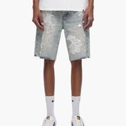 Person wearing light blue denim shorts with white floral patterns on a white background
