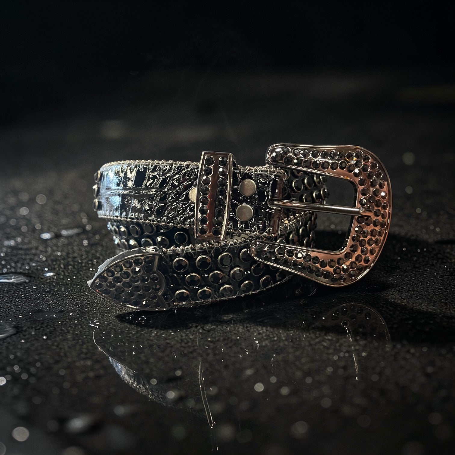 Decorative belt with intricate design on a dark, reflective surface