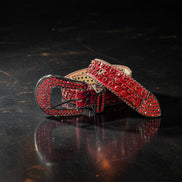 Red belt with decorative buckle on a dark surface
