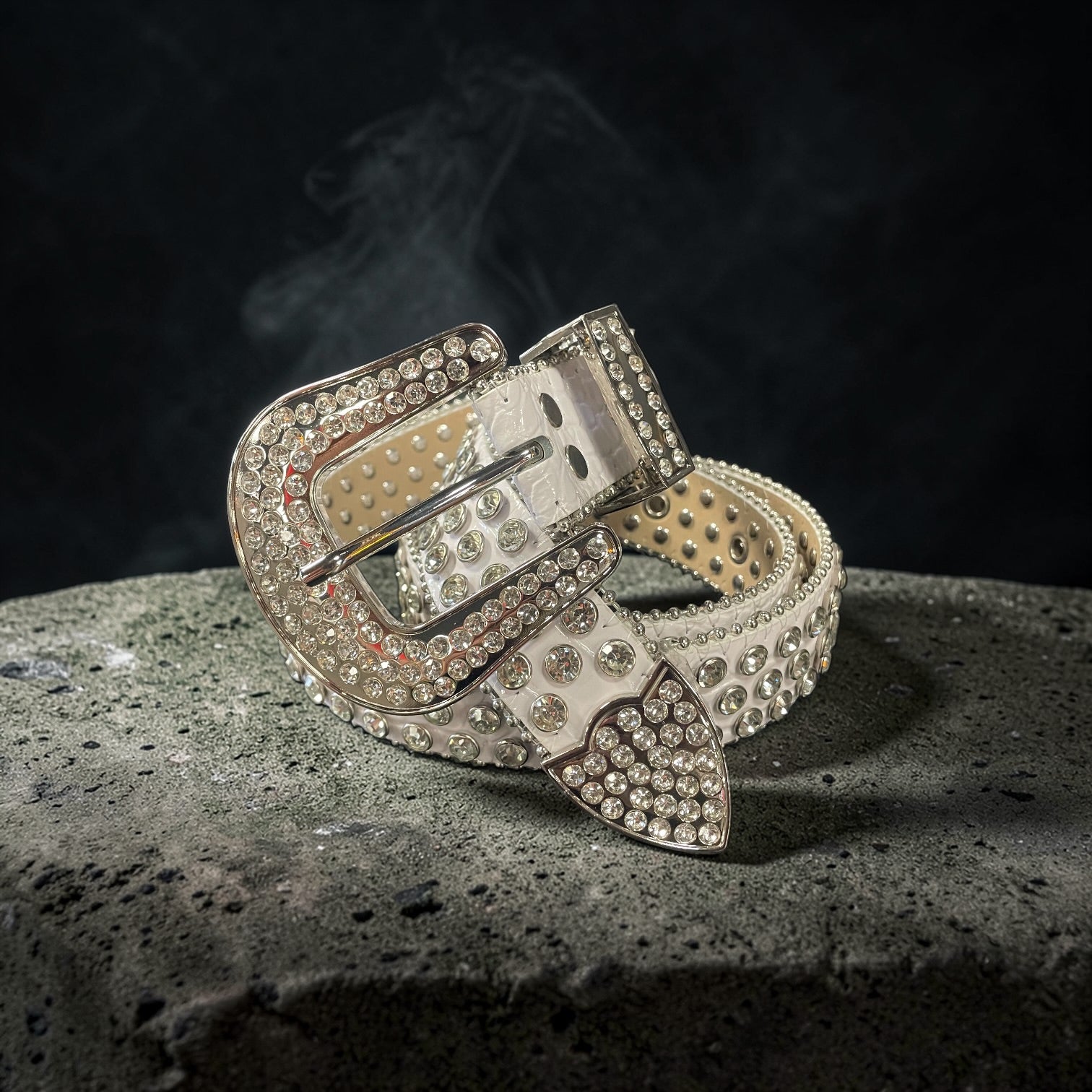 Decorative belt with rhinestone buckle on a textured surface