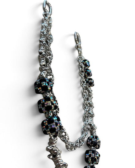 A silver-toned chain accessory with multiple black faceted beads that shimmer with iridescent rainbow reflections, photographed on a clean white background.