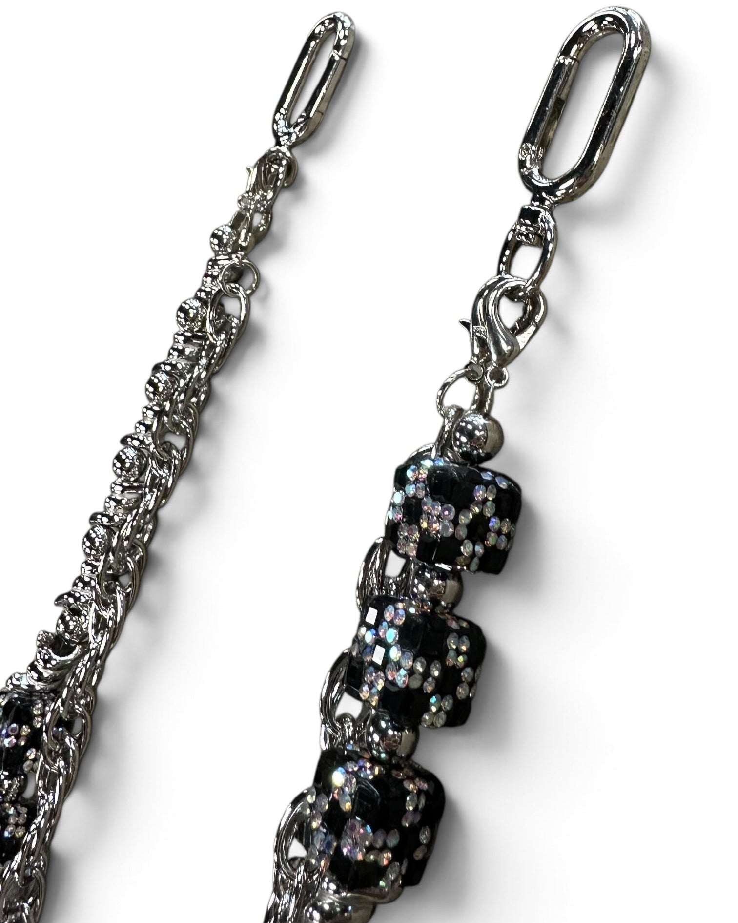 A close-up of a silver-toned chain strap with a decorative dangling section featuring black faceted rhinestone beads and silver hardware, shown on a plain white background.