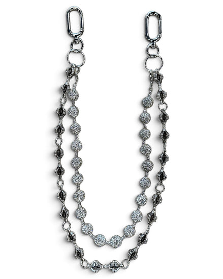 A silver-toned double-strand chain accessory featuring textured oval links, round pavé-style discs, and elongated drop links, displayed on a clean white background.