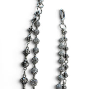 A close-up of a silver-toned beaded chain accessory with textured round beads and lobster clasp ends, shown on a plain white background.