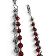 A pair of silver-toned chain earrings with faceted red beads and silver-toned decorative links, shown on a plain white background.