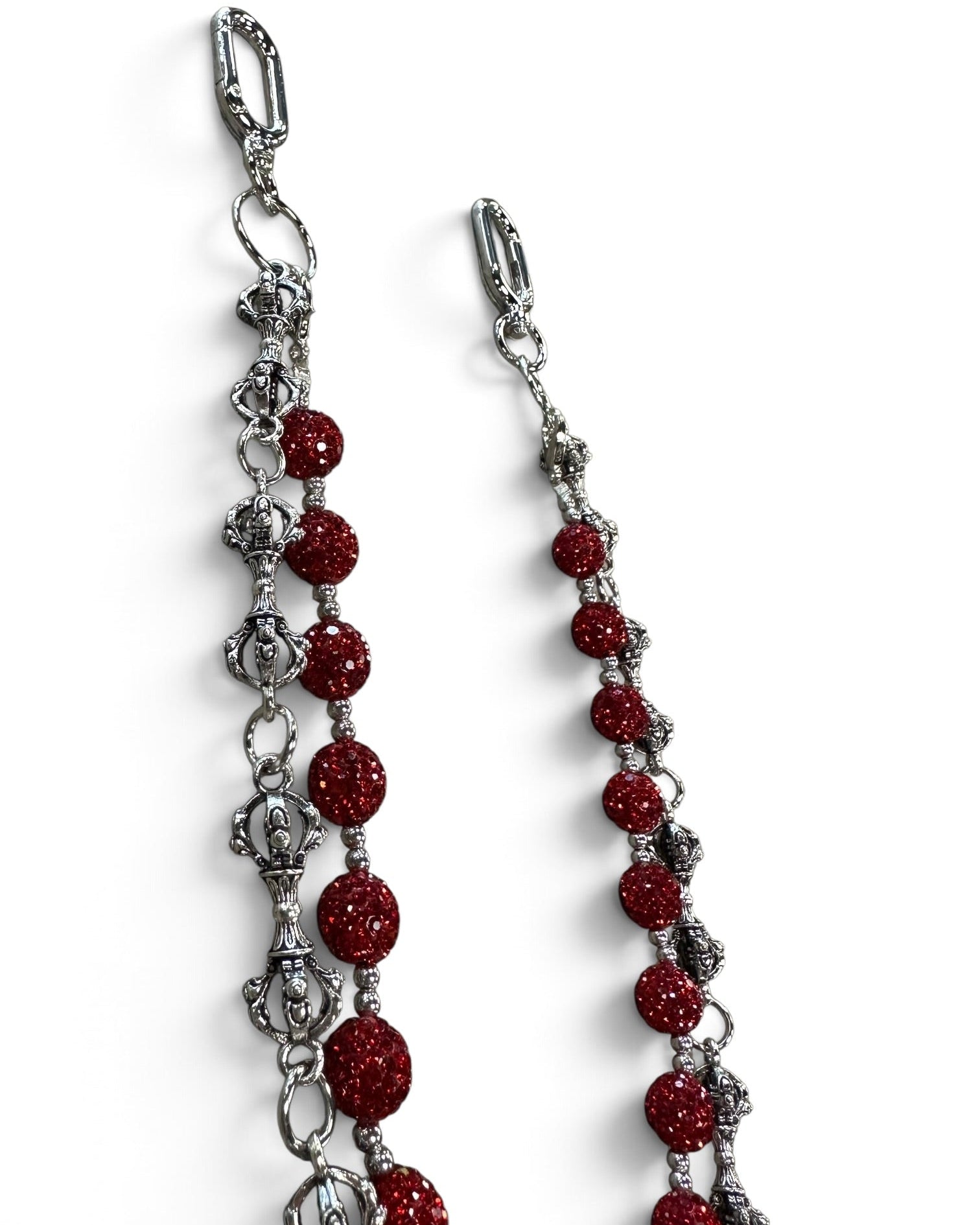 A pair of silver-toned chain earrings with faceted red beads and silver-toned decorative links, shown on a plain white background.