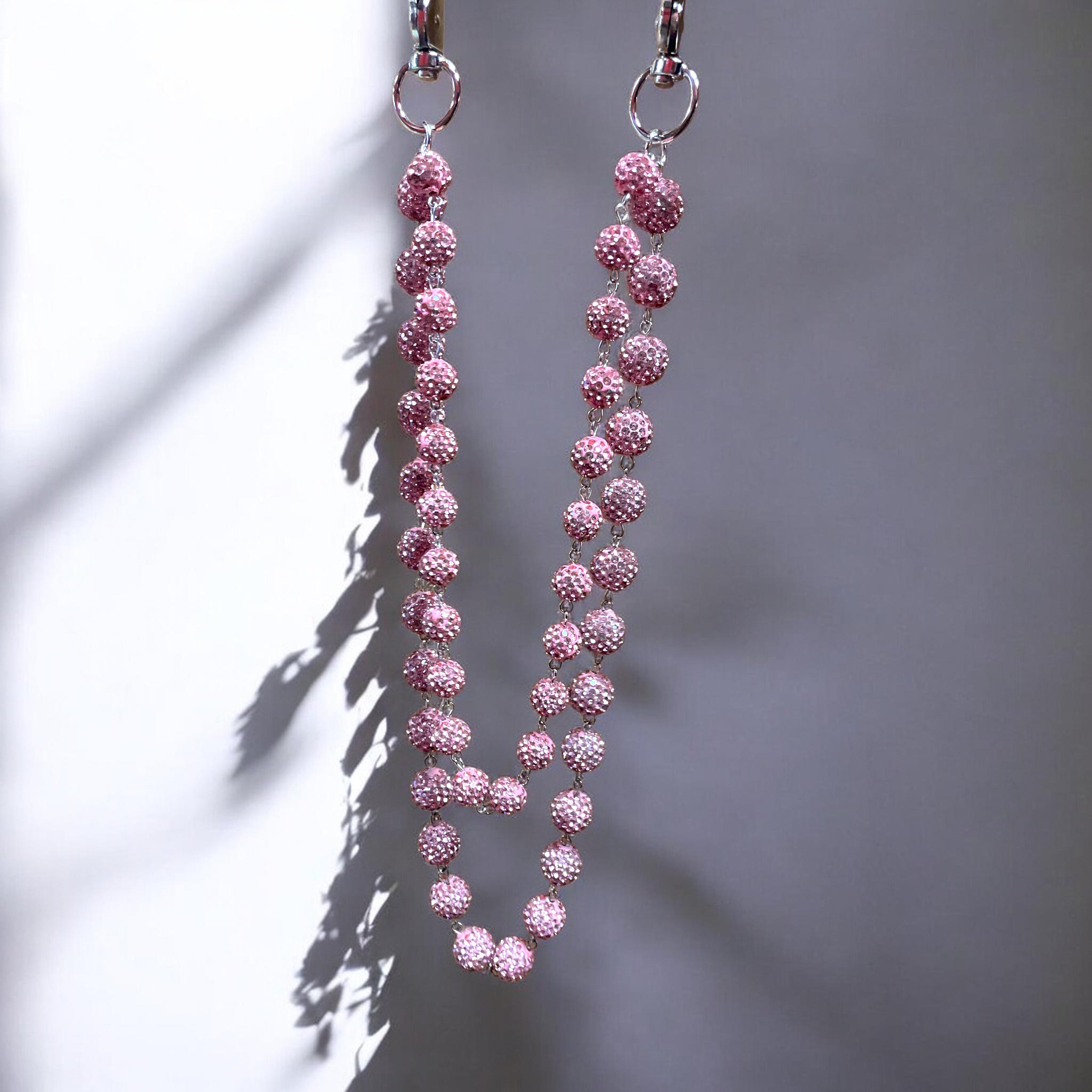 Pink beaded wallet chain on a gray background