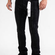 Person wearing black jeans with a brand tag on a white background