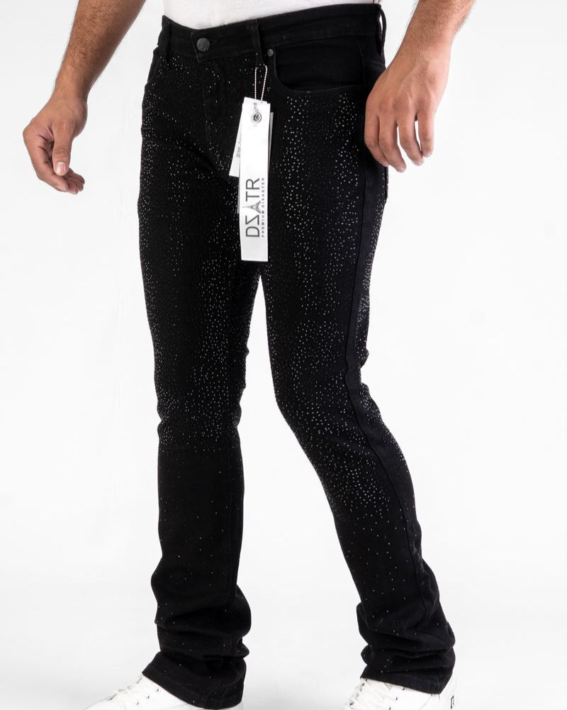 Person wearing black jeans with a tag, standing against a white background