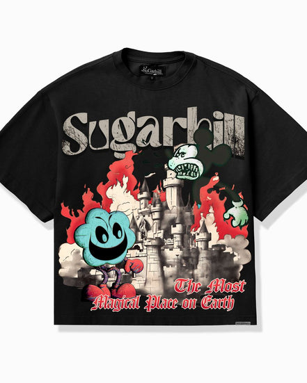 A black short-sleeve graphic T-shirt laid flat against a light gray background. The front features a large multicolor print with the word 'Sugarhill' in distressed white lettering, a gray castle, red flames, a blue smiling ghost-like character, and red script text reading 'The Most Magical Place on Earth.
