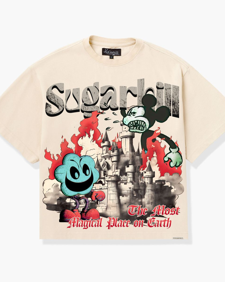 A cream-colored graphic t-shirt featuring a stylized Mickey Mouse design with the text 'Sugarhill' and 'The Most Magical Place on Earth'. The graphic includes a castle, red flames, and a blue character, set against a light gray background.