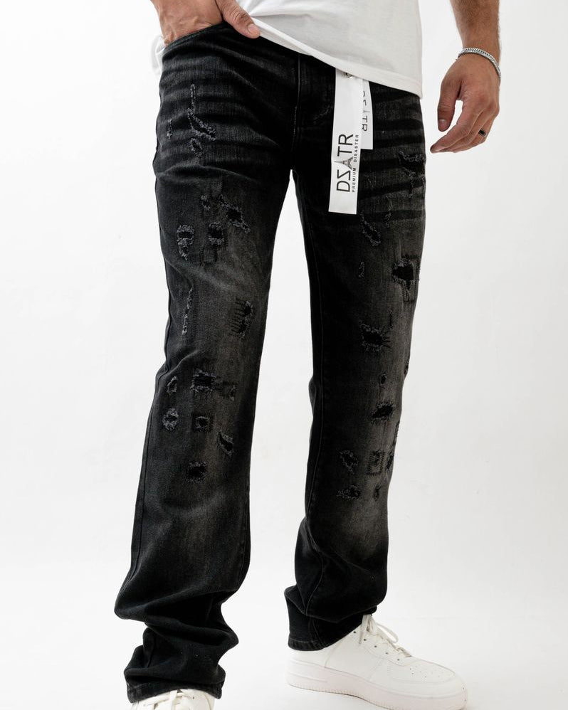 Person wearing black distressed jeans with a white label on a white background