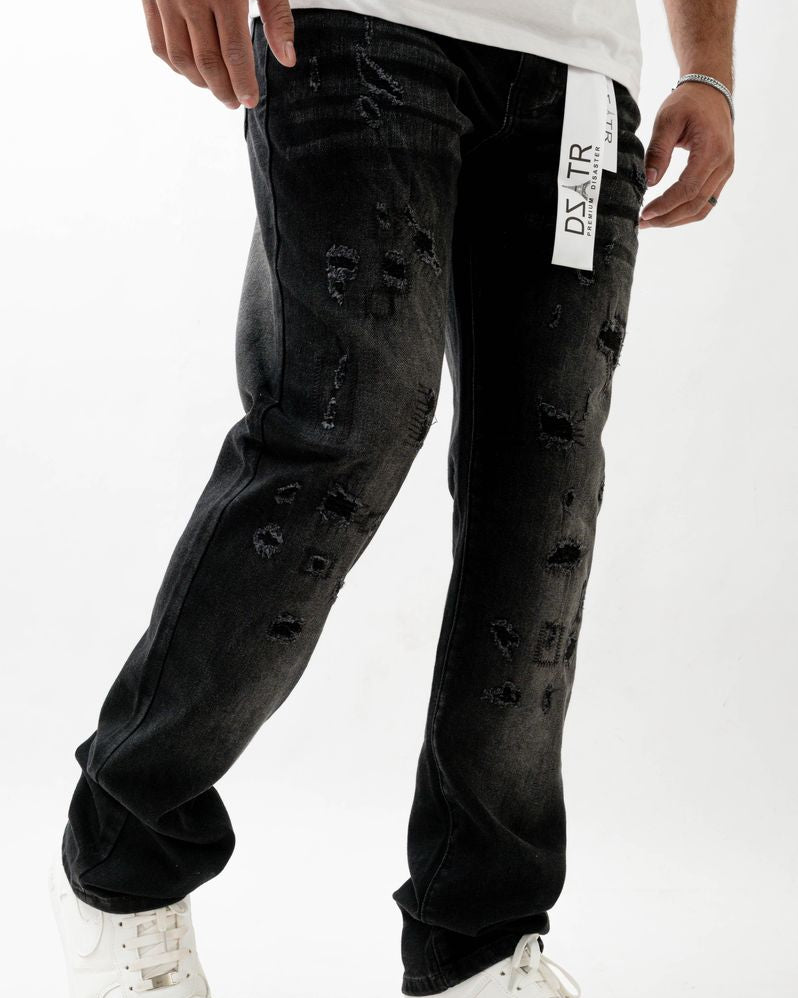 Person wearing black distressed jeans with a visible brand label on a white background