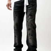 Person wearing black distressed jeans with a white background
