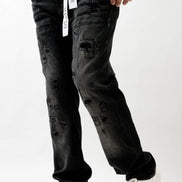 Person wearing black distressed jeans and white sneakers on a white background