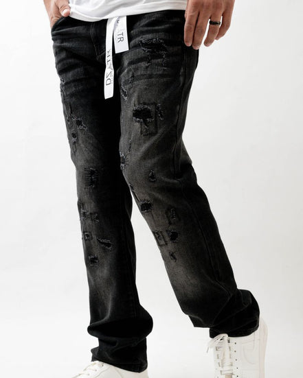 Person wearing black distressed jeans and white sneakers on a white background