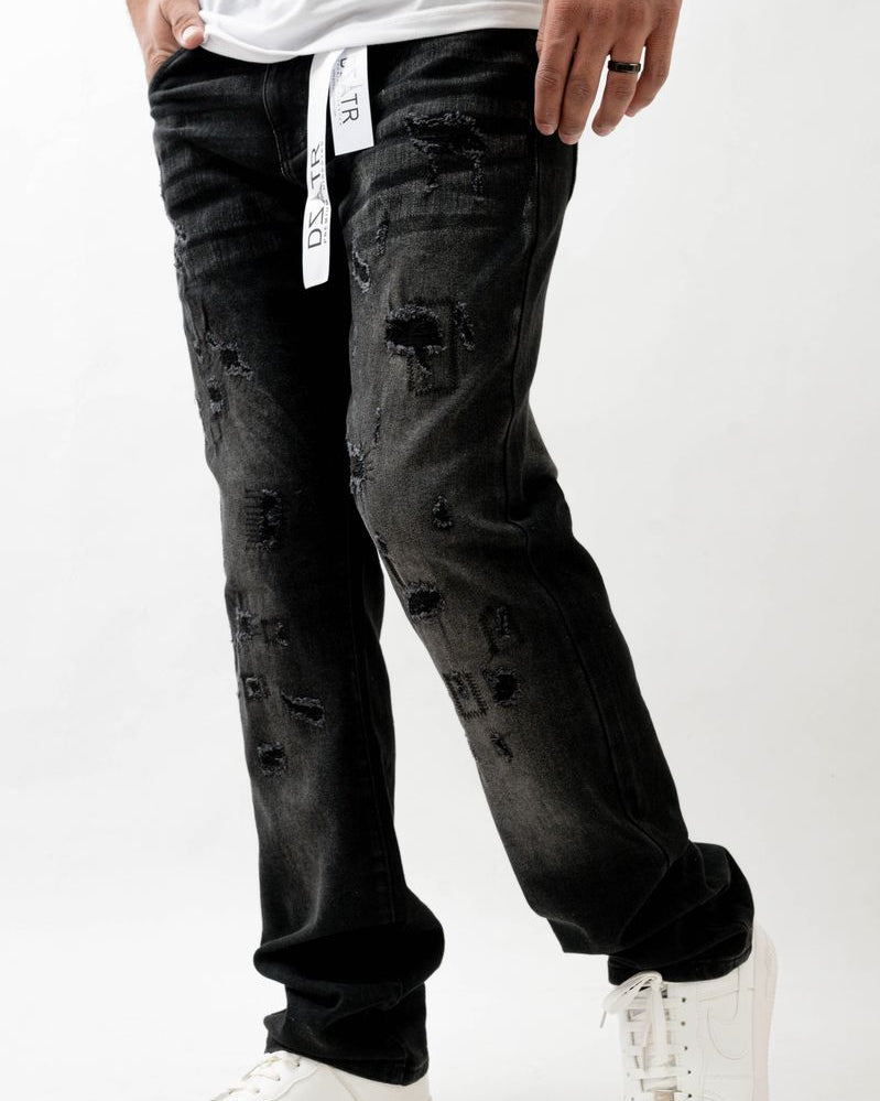 Person wearing black distressed jeans and white sneakers on a white background