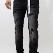 Person wearing black distressed jeans with a visible brand label on a white background