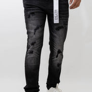 Person wearing black distressed jeans with a visible brand label on a white background