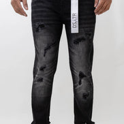 Person wearing black distressed jeans with a visible brand tag on a white background