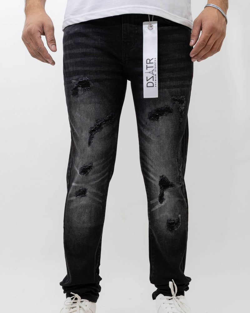 Person wearing black distressed jeans with a visible brand tag on a white background