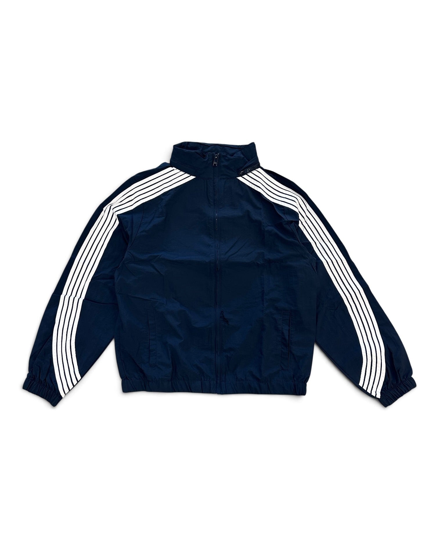 A navy blue track jacket with three white stripes running down the sleeves, laid flat against a white background.