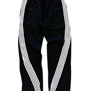 Black track pants with three white stripes running down the sides, featuring an elastic waistband and drawstring.