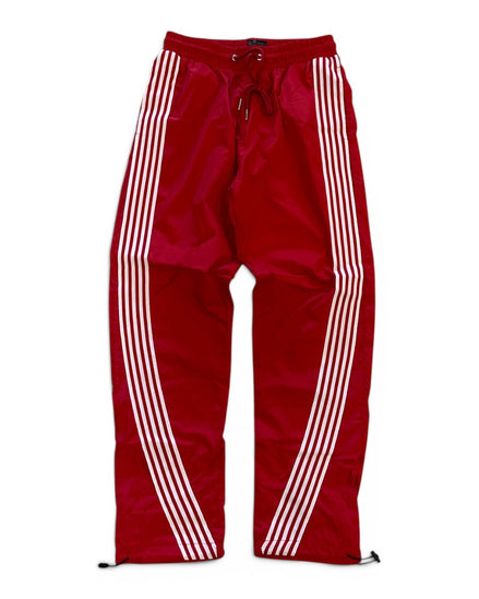 Red track pants with white stripes on a white background