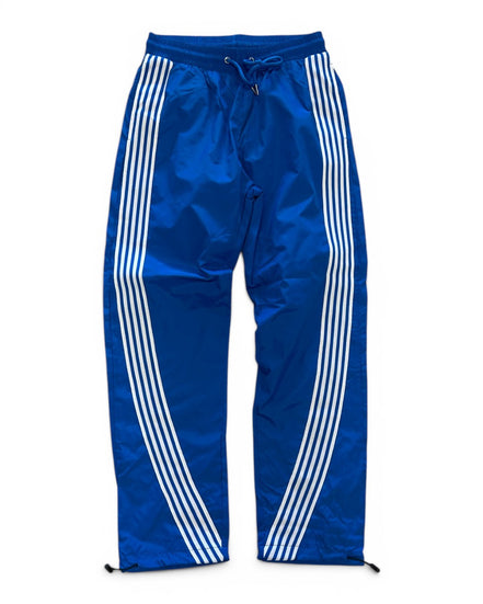 Blue track pants with white stripes on a white background