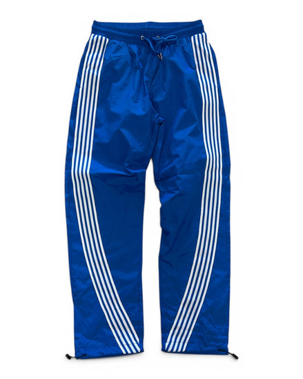 Blue track pants with white stripes on a white background