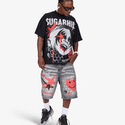 A man modeling a black graphic t-shirt with 'SUGARHILL' text and a clown print, paired with gray distressed shorts featuring red smiley face graphics, white socks, and black sneakers, against a light gray background.