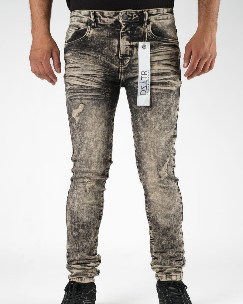 Person wearing distressed gray jeans with a brand tag on a white background