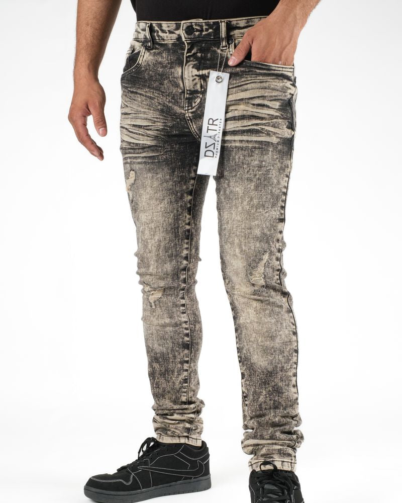 Person wearing distressed gray jeans with a brand tag on a white background