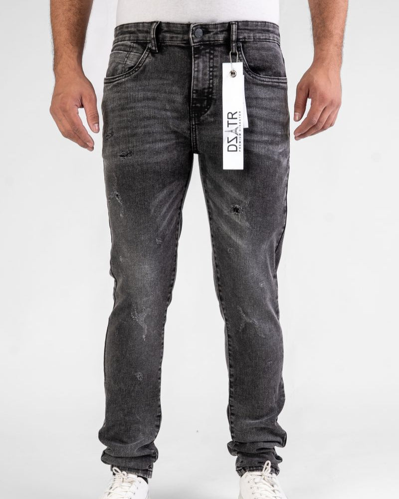 Black distressed jeans with a brand tag on a white background