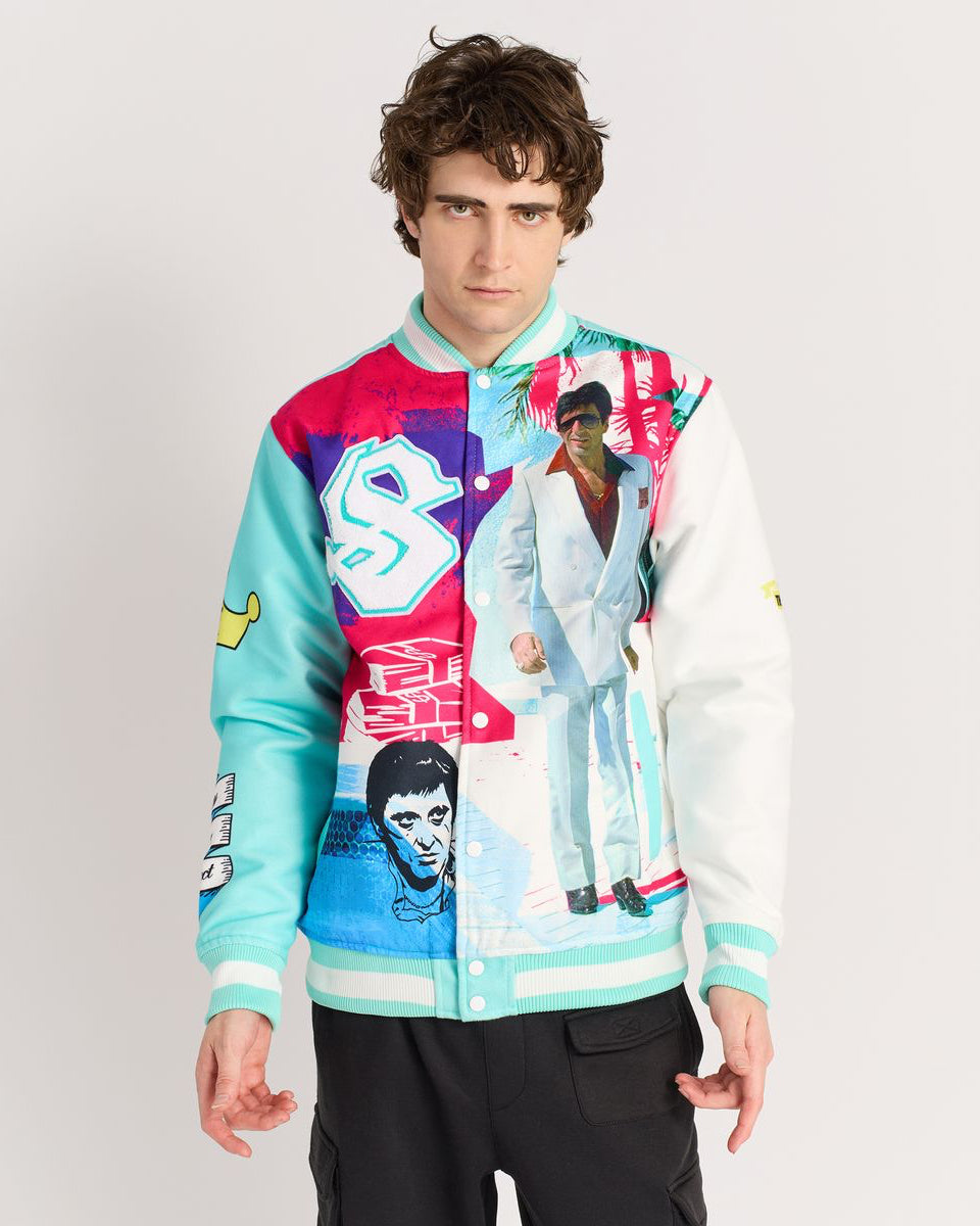 Person wearing a colorful jacket with graphic designs on a plain background