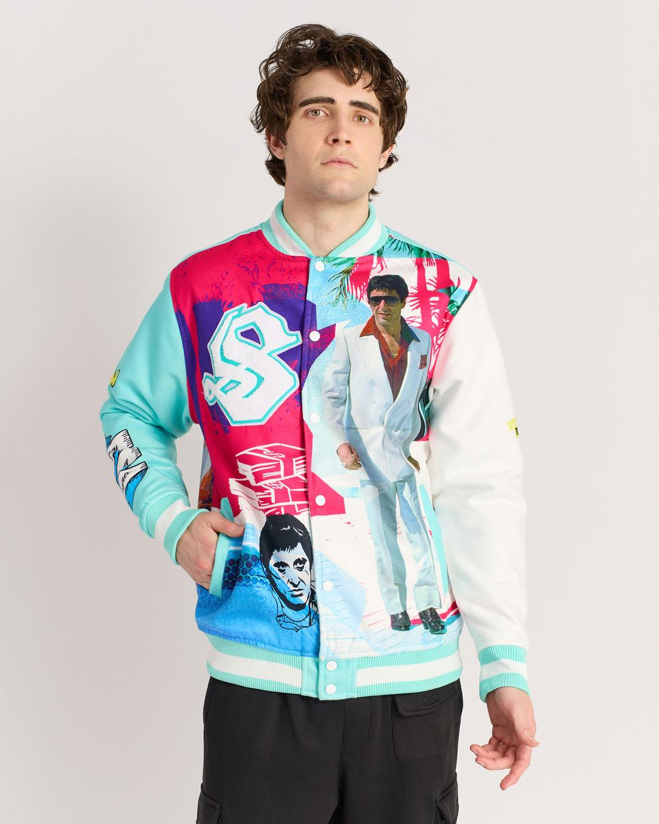 Person wearing a colorful jacket with graphic designs on a plain background