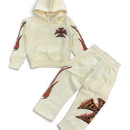 A two-piece baby clothing set consisting of a cream-colored hooded sweatshirt and matching jogger pants, both decorated with red and black flame and cross graphics.
